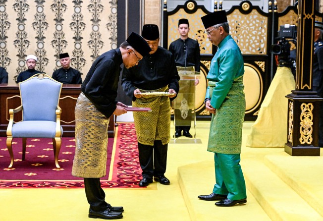 Malaysia’s King Sultan Abdullah Sultan Ahmad Shah and newly appointed Prime Minister Anwar Ibrahim (left) take part in the swearing-in ceremony at the National Palace in Kuala Lumpur on November 24. Photo: Reuters