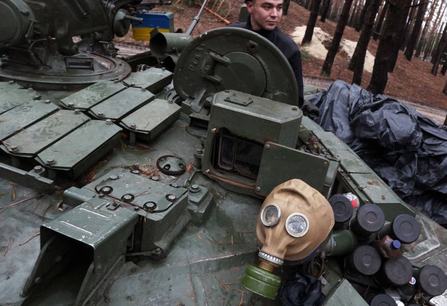 A Ukrainian serviceman repairs a captured Russian tank in a forest near the front line in the Kharkiv region. Photo: AFP