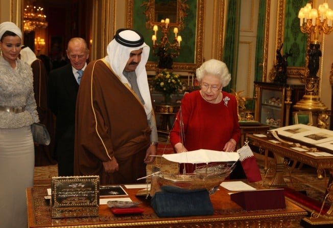 The late Queen Elizabeth shows the former Emir of Qatar, Sheikh Hamad bin Khalifa al-Thani, around exhibits with one of his three wives, Sheikha Mozah bint Nasser Al-Missned, from the Royal Collection at Windsor Castle during his state visit in 2010. Photo: Getty Images