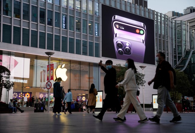 People walk near a display advertising the iPhone 14 outside an Apple store in Shanghai, China. Photo: Reuters