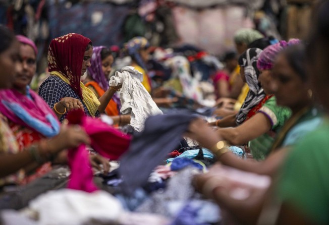 Workers at Canam sift through piles of clothes. Photo: Prashanth Vishwanathan / Bloomberg