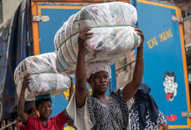 “Kayayei” transport bales of discarded clothes weighing up to 50kg to stalls at Ghana’s Kantamanto Market. Photo: Andrew Caballero-Reynolds / Bloomberg