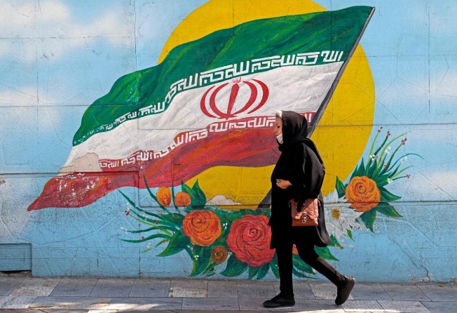 A woman walks past a mural in the Iranian capital Tehran. Photo: AFP