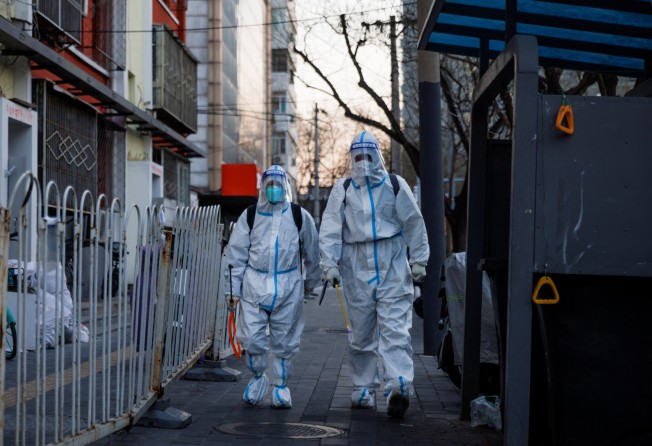 Pandemic prevention workers in protective suits in Beijing on Sunday. Photo: Reuters