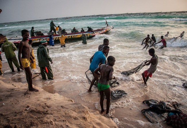 Fishermen and boys are seen in Port de Pêche, Nouakchott, Mauritania, Africa, on 24 May, 2014. Photo: Michal Huniewicz via Wikimedia Commons (CC BY-SA 3.0), cropped