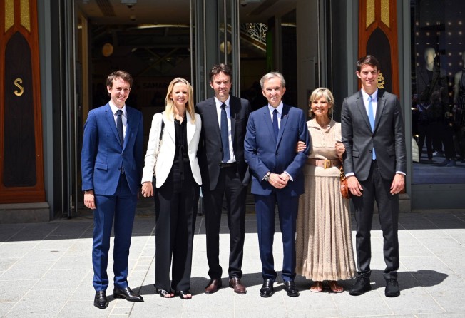 Head of French multinational corporation LVMH Bernard Arnault (centre) and his wife Helene (second from right), surrounded by their children (from left) Frederic, Delphine, Antoine and Alexandre pose during attend a ceremony marking Paris’ iconic department store La Samaritaine reopening after 16 years of closure in Paris, in June 2021. Photo: AFP