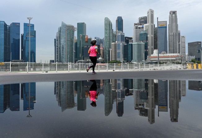 A woman jogs past Singapore’s skyline. Photo: AFP