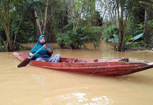 Phaisah Tuamngam paddles amid a flood in Yala province, Thailand. She used the boat to distribute food and other items to her neighbours last year. Photo: Handout