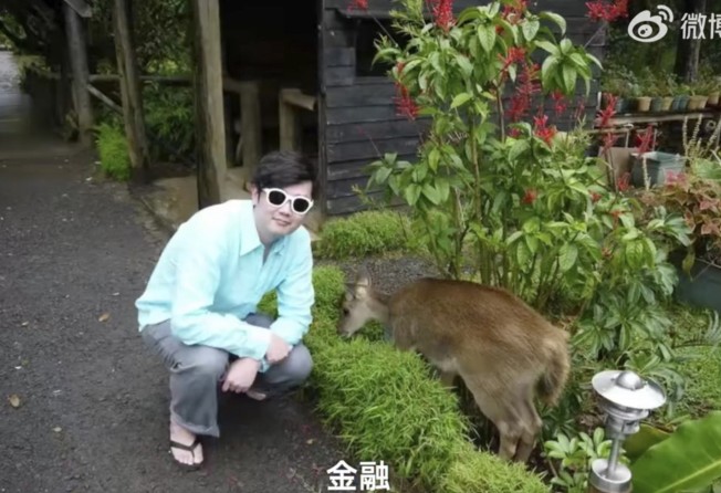Huang down on the farm with one of his brown goats. Photo: Weibo