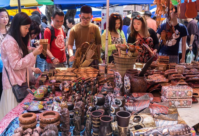 Chinese tourists buying local craft items at a market in Kota Kinabalu Sabah in 2015. Photo: Shutterstock