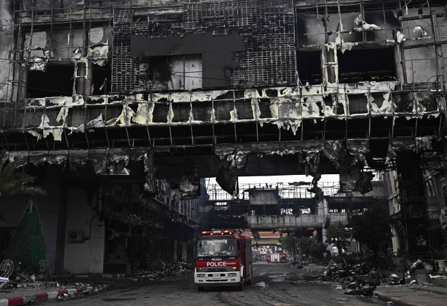 A police vehicle under a destroyed part of the Grand Diamond City hotel-casino following a major fire in Poipet on Thursday. Photo: AFP