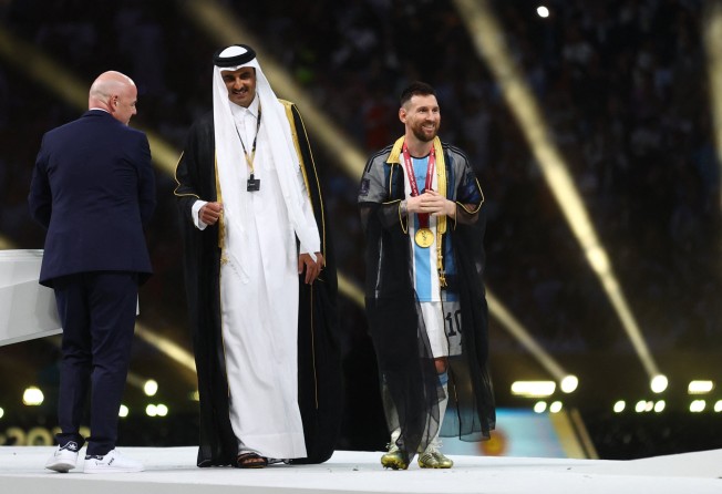Argentina’s Lionel Messi wears a robe from the Emir of Qatar, Sheikh Tamim bin Hamad Al Thani, and Fifa president Gianni Infantino during the World Cup trophy ceremony. Photo: Reuters