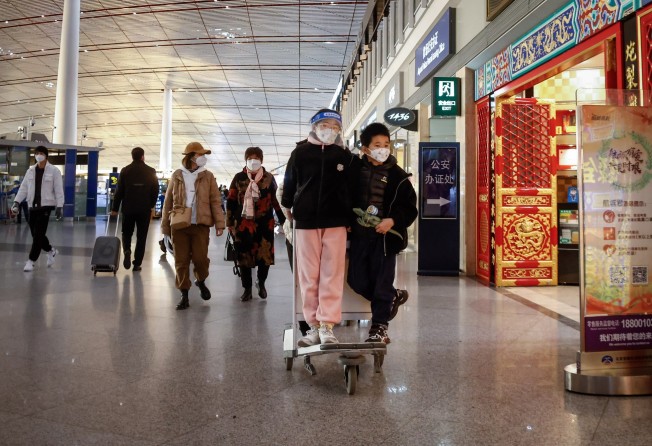 Passengers wearing walk through Beijing Capital International Airport last month. Photo: EPA-EFE