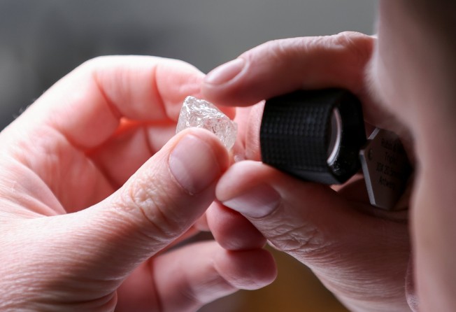 An employee holds a rough diamond at the Diamonds of Alrosa factory in Moscow, Russia. Photo: Reuters