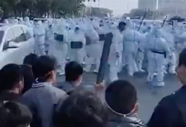 Foxconn workers confront security personnel wearing hazmat suits in Zhengzhou in November. Photo: Weibo