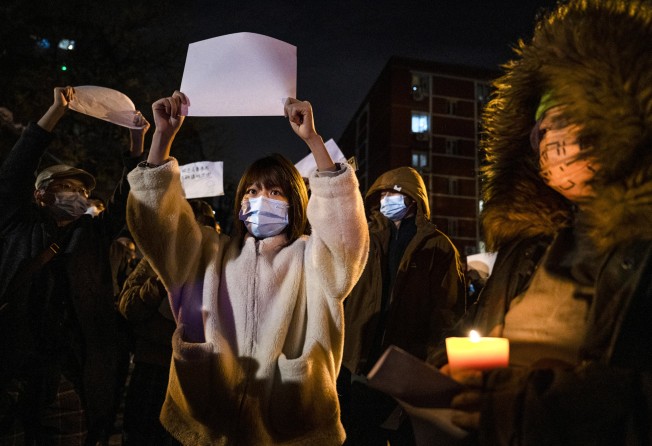 People hold up sheets of blank paper to criticise censorship as they march in Beijing on November 27 during a protest against the country’s strict zero-Covid measures. Photo: Getty Images/TNS