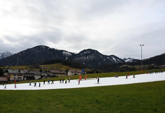 People ski down an artificial snow slope near the Bavarian village of Ruhpolding, Germany, on January 11. Many ski resorts across Europe are suffering a lack of snow amid high temperatures as Europe experiences an unusually warm winter. Photo: AFP