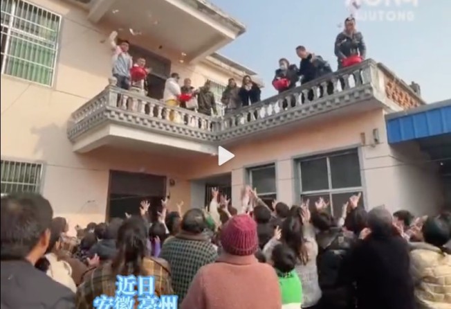 Guests lost it when the family began throwing hundred yuan notes from their first-floor balcony during the party. Photo: Weibo