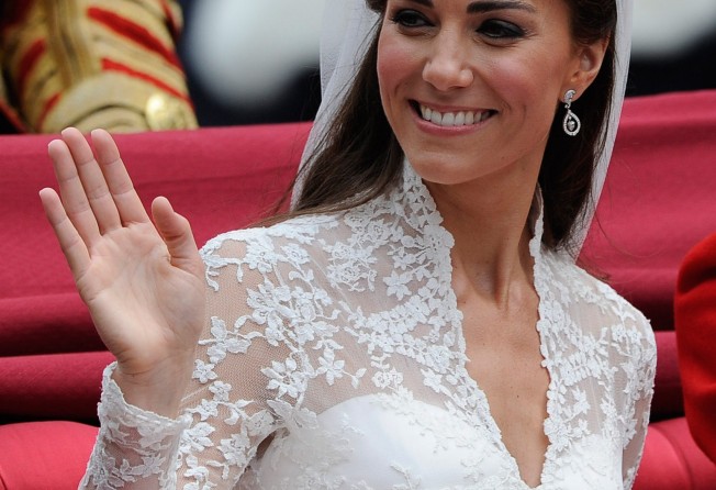 Catherine, Duchess of Cambridge waves as she travels in the 1902 State Landau carriage on the procession route along The Mall to Buckingham Palace after her wedding ceremony at Westminster Abbey in April 2011, in London, England. Photo: Getty Images