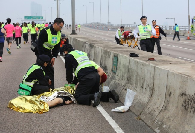 A runner is attended to by paramedics on the side of the road of Island Eastern Corridor during the 10km race of the 2018 Standard Chartered Hong Kong Marathon. Photo: Felix Wong
