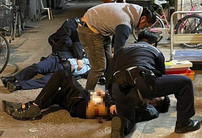 Police attend to a 43-year-old Filipino man who was hit by three shots in thewaist and arm. Photo: Handout