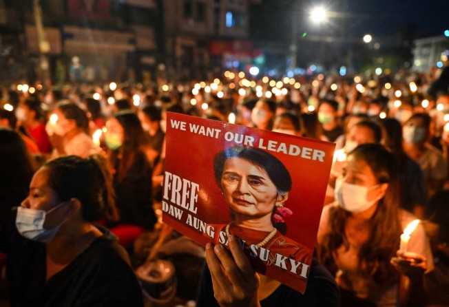 A protester holds a poster with an image of detained civilian leader Aung San Suu Kyi during a candlelight vigil in March 2021 to honour those who have died during demonstrations against the military coup in Yangon. Photo: AFP