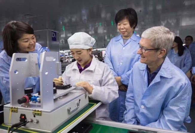 Luxshare Precision Industry Co chairwoman Grace Wang Laichun stands behind Apple chief executive Tim Cook during his visit to the Chinese firm’s AirPods assembly line in Kunshan, a city in eastern Jiangsu province, on December 4, 2017. Photo: Handout