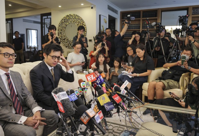 Joseph Lam Chok (in dark suit), one of at least 11 people arrested in connection with the JPEX scandal, held a press briefing at his Mid-Levels home on September 18. Photo: Jelly Tse