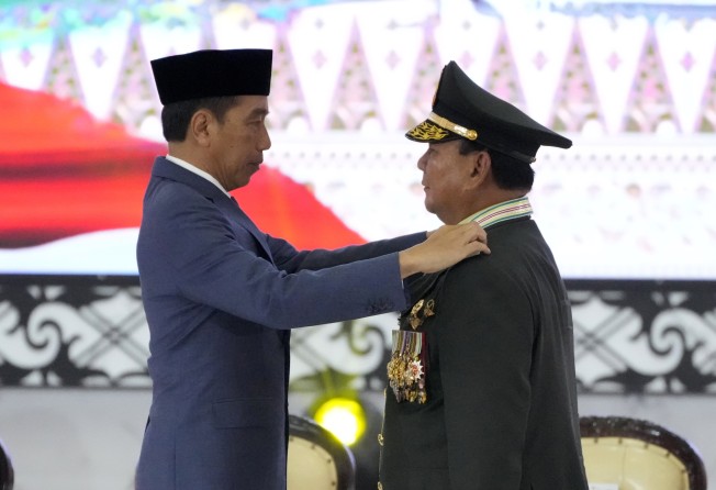 Indonesian Defence Minister Prabowo Subianto, right, receives four-star general epaulettes from President Joko Widodo on Wednesday. Photo: AP
