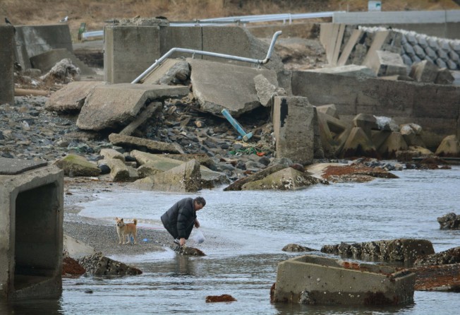 A man strolls on a beach surrounded by rubble in Minamisanriku, Miyagi prefecture on March 9, 2014, two days before the third anniversary of March 11, 2011 earthquake and tsunami. Photo: AFP