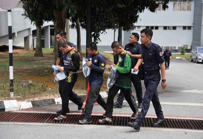 Three members of GISBH escorted by Malaysian police officers depart after facing charges at a court in Seremban on September 19. Photo: EPA-EFE
