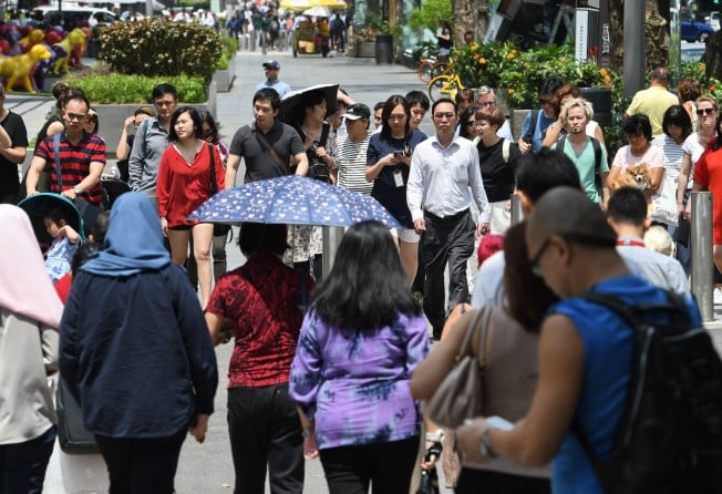Pedestrians in the Orchard Road shopping district in Singapore in 2018. Chinese names were once pronounced according to a person’s local dialect. This is dying out. Photo: AFP