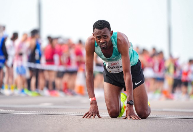 Ethiopia’s Milkesa Mengesha is on his knees after winning the Hong Kong-Zhuhai-Macau Bridge Half Marathon. Photo: Eugene Lee