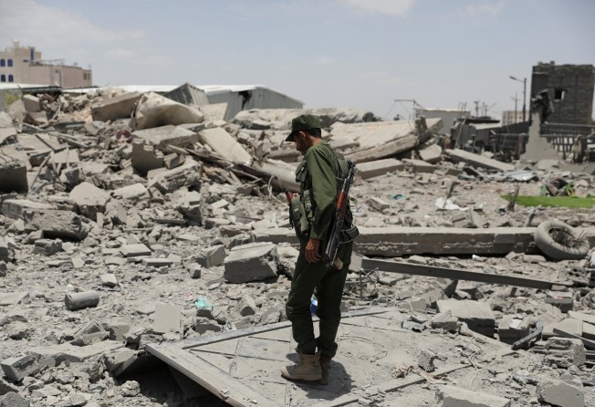 A police trooper stands on the rubble of a building destroyed by US air strikes in Sanaa, Yemen. Photo: Reuters