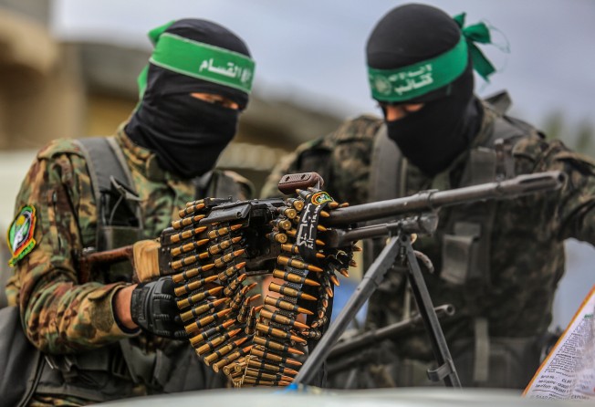 Members of the military wing of Hamas form a corridor as Israeli hostages get delivered to representatives of the International Committee of the Red Cross on February 8. Photo: dpa