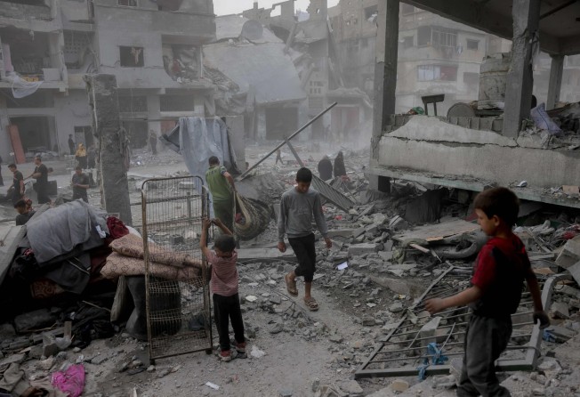Palestinians salvage items from the rubble of the Fatima Bint Asad school hit in overnight Israeli strikes in Jabalia in the northern Gaza Strip on Monday. Photo: AFP