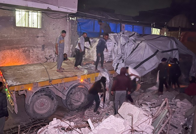 Palestinian workers unload sacks of flour from an aid truck at a bakery in Khan Younis on Wednesday. Photo: Reuters