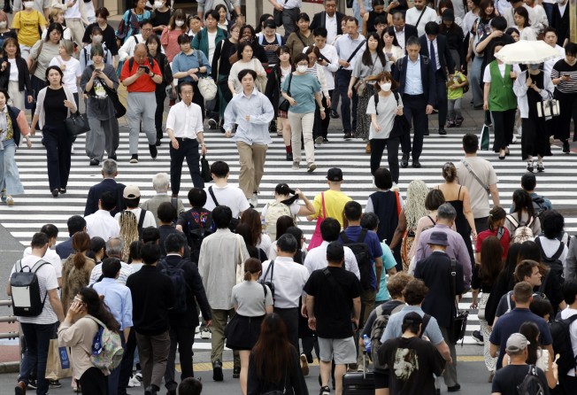 Pedestrians walk through a crossing in Tokyo. A lawmaker says Japan’s business manager visa has become an “easy route” to residency. Photo: EPA-EFE