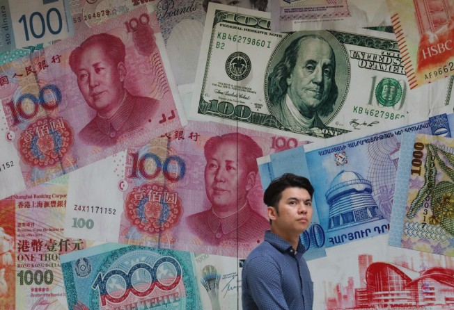 A man walks past a money exchange shop in Central, Hong Kong. The nation’s latest five-year plan calls on Hong Kong to enhance its role as an international financial hub and expand its offshore renminbi business.Photo: Felix Wong