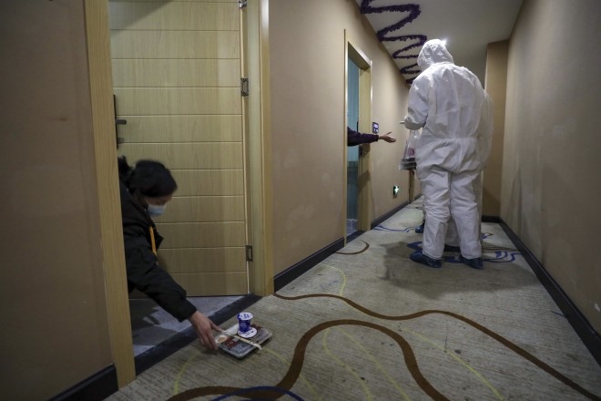 Workers in protective suits hand out meals to patients under quarantine at a hotel in China on February 3.