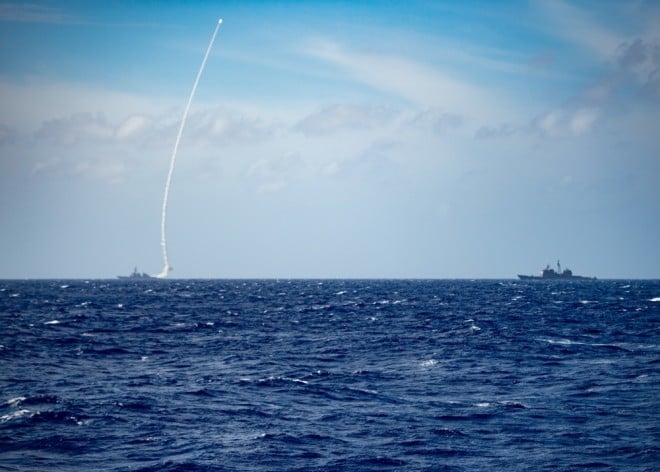 The guided-missile destroyer USS Barry (left) launches a missile during a live-fire exercise on Thursday.