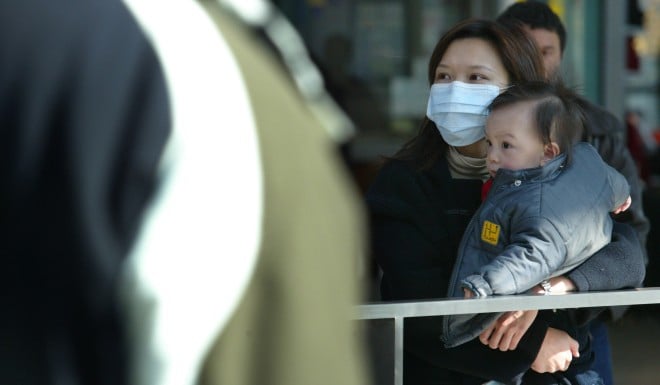 A woman travels with a baby during the Sars outbreak in December 2003.
