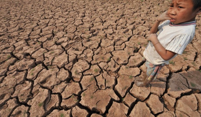 A farmer's son stands in a dried up field near the Mekong in Laos.