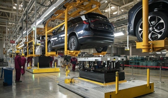 Employees install batteries onto an electric sport utility vehicle (SUV) during a media tour of the Nio production facility in Hefei, Anhui province, in December 2020. Photo: Bloomberg