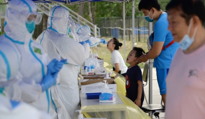 Medical workers in protective suits conduct nucleic acid test for residents, following a new outbreak of the coronavirus disease (COVID-19) in Beijing, on June 20, 2020. Photo: Reuters