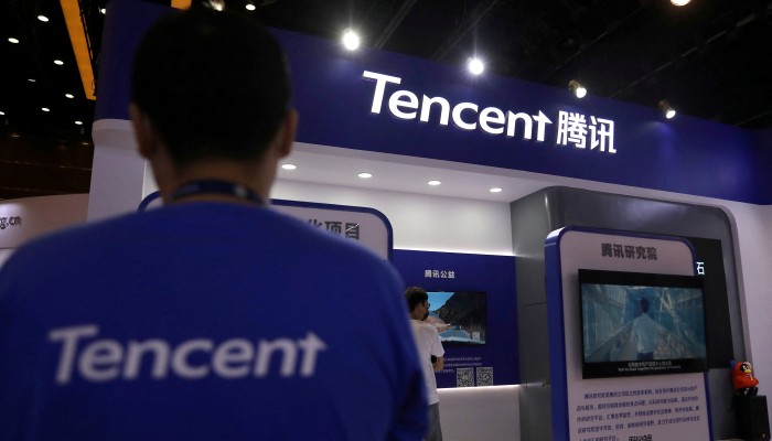 An employee stands in front of the Tencent store.