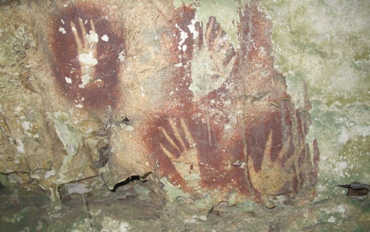 Handprints with sharpened fingertips on a cave wall in the Maros region of Sulawesi, Indonesia. Photo: Ahdi Agus Oktaviana/Maxime Aubert/AP