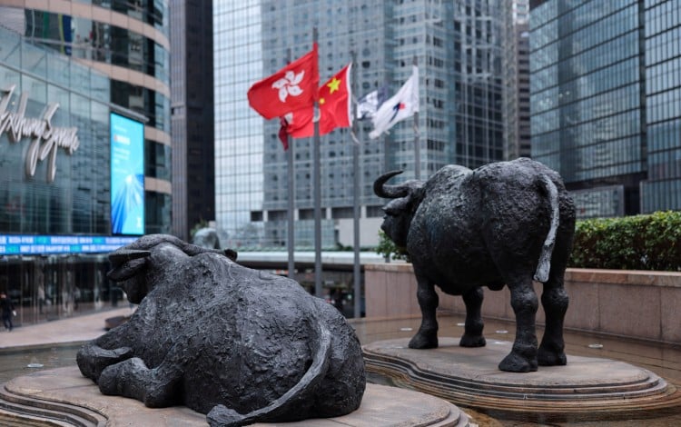 Bull statues stand near screens showing the Hang Seng Index at Exchange Square in Hong Kong, home of the city’s bourse operator, on February 3, 2026. Photo: Reuters