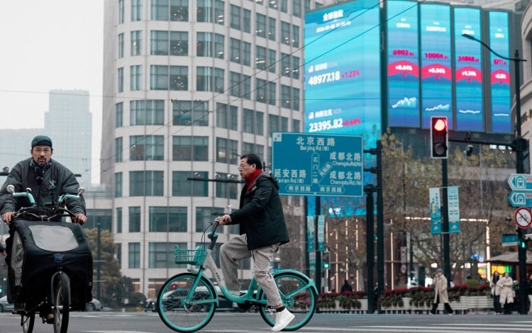 A huge screen displays the latest stock exchange and economic data in Shanghai. Photo: EPA