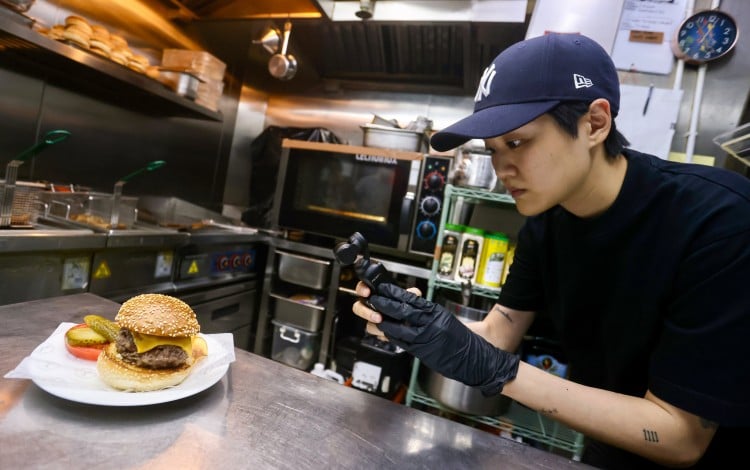 Mel Ng records video of a Diplomat Burger that she prepped at The Diplomat in Central, Hong Kong. The Diplomat was the 31st stop in Ng’s stagiaire series on Instagram. Photo: Jonathan Wong